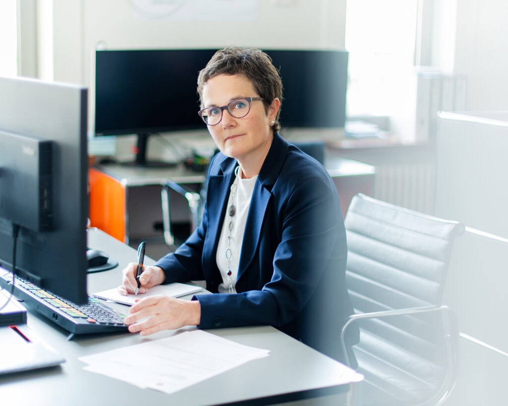 Hochwertiger Portraitfotografie eines professionellen Frauen in einem modernen Büro.