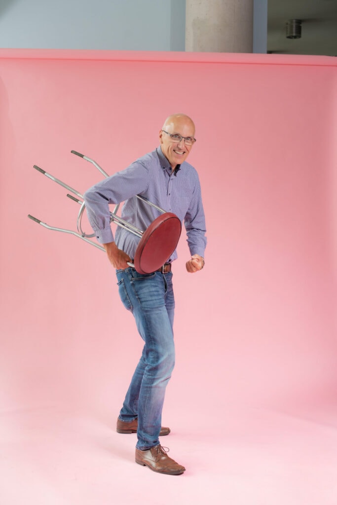 Kiefernschüsseln und Stühle, die auf dem pinkfarbenen Hintergrund im Fotostudio gestellt wurden.