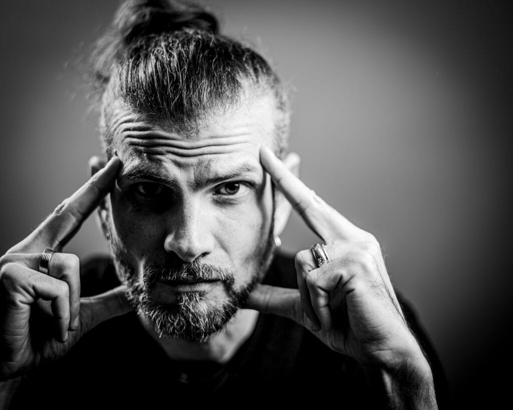 Dynamische Schwarz-Weiß-Porträtaufnahme eines Mannes mit intensiver Ausstrahlung, die die künstlerische Fotografie von Frank Siemers aus Hamburg zeigt.