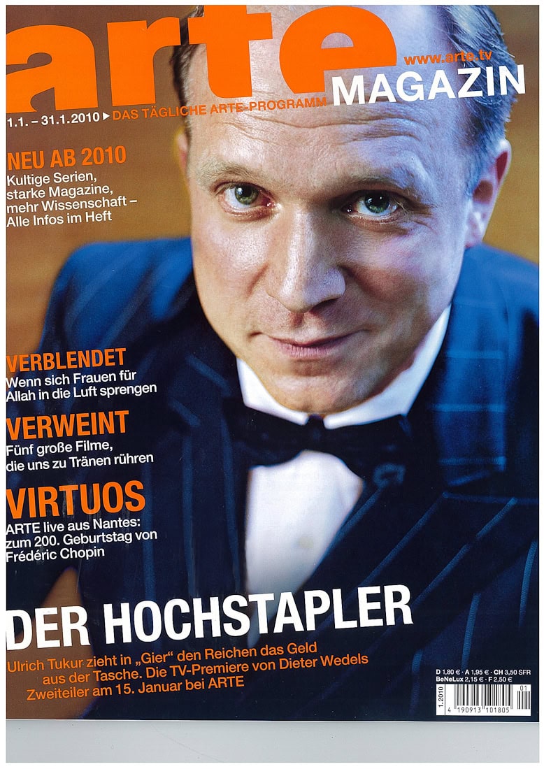 Fotografisches Werk von Frank Siemers: Portrait eines Mannes in formellem Anzug mit blauer Jacke und Fliege, Fokus auf das Gesicht, detailreich und professionell aufgenommen.