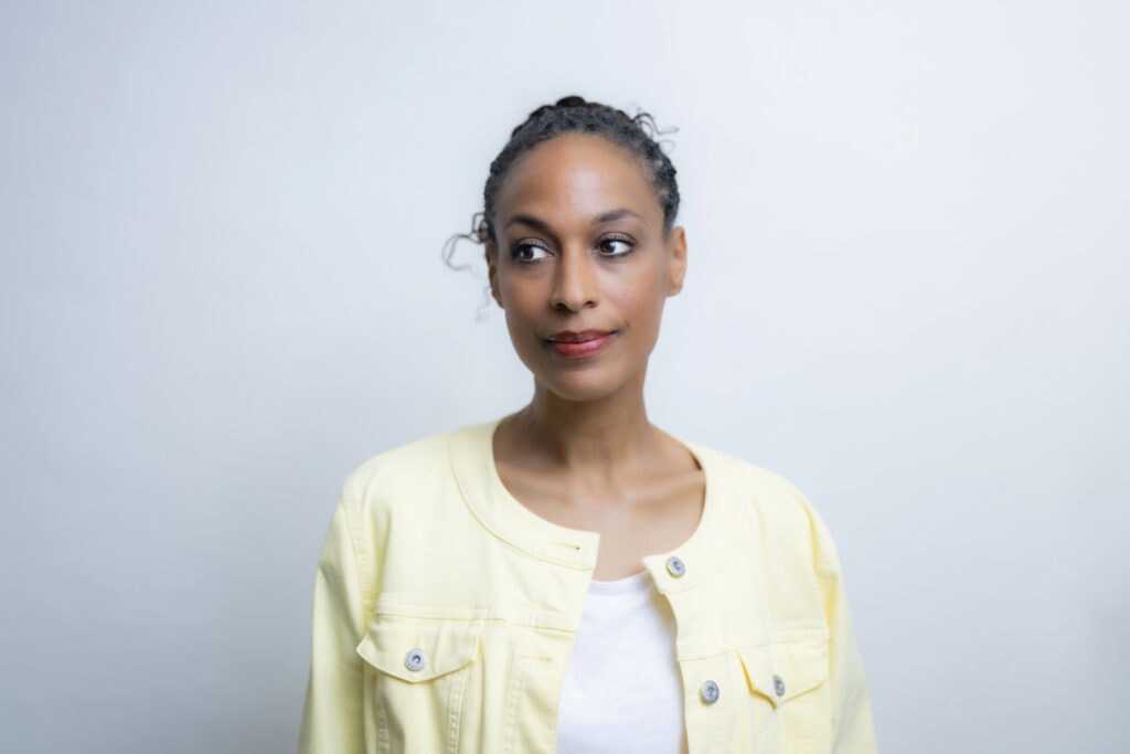 Natürliche Portraitaufnahme einer jungen Frau vor hellem Hintergrund, professionelles Fotografie-Portfolio, Hamb, Deutschland.