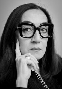 Großer schwarz-weißer Portraitfotografie eines nachdenklichen Frauenportraits, Fokus auf Gesicht und Accessoires.